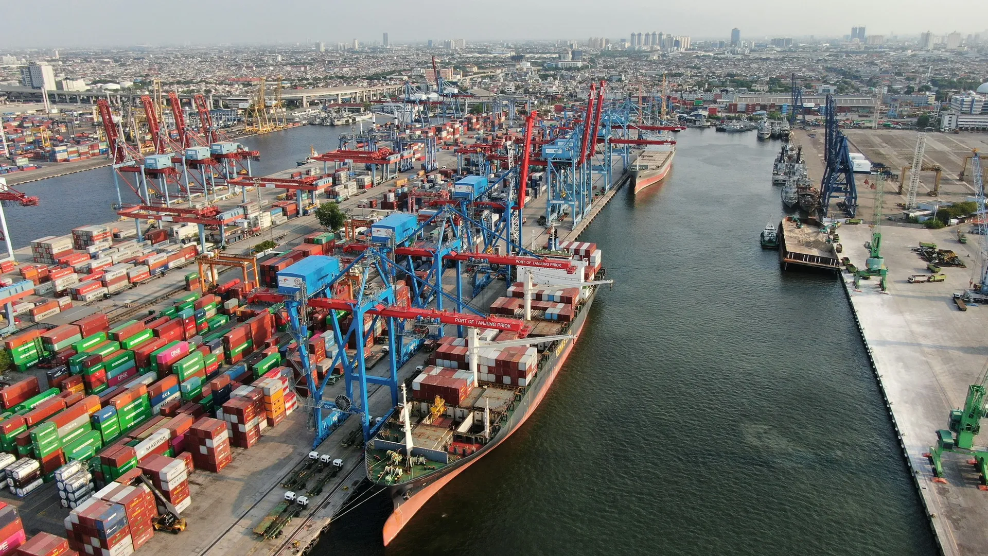 Terminal portuaria de contenedores con grúas cargando un buque.